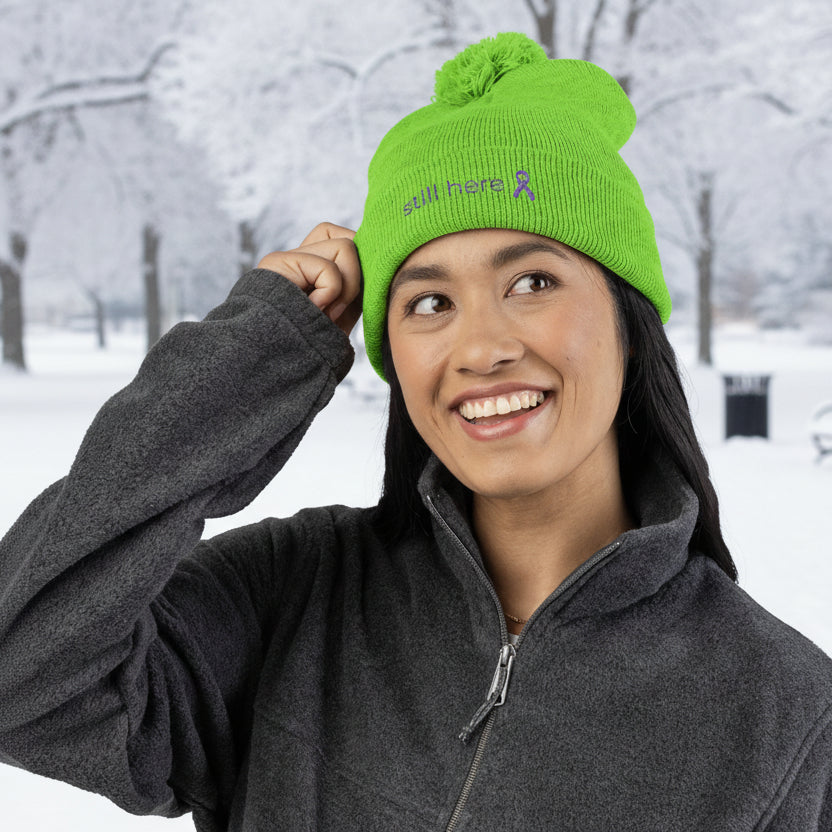 Still Here Pom-Pom Beanie – Epilepsy Awareness Knit Hat with Purple Ribbon