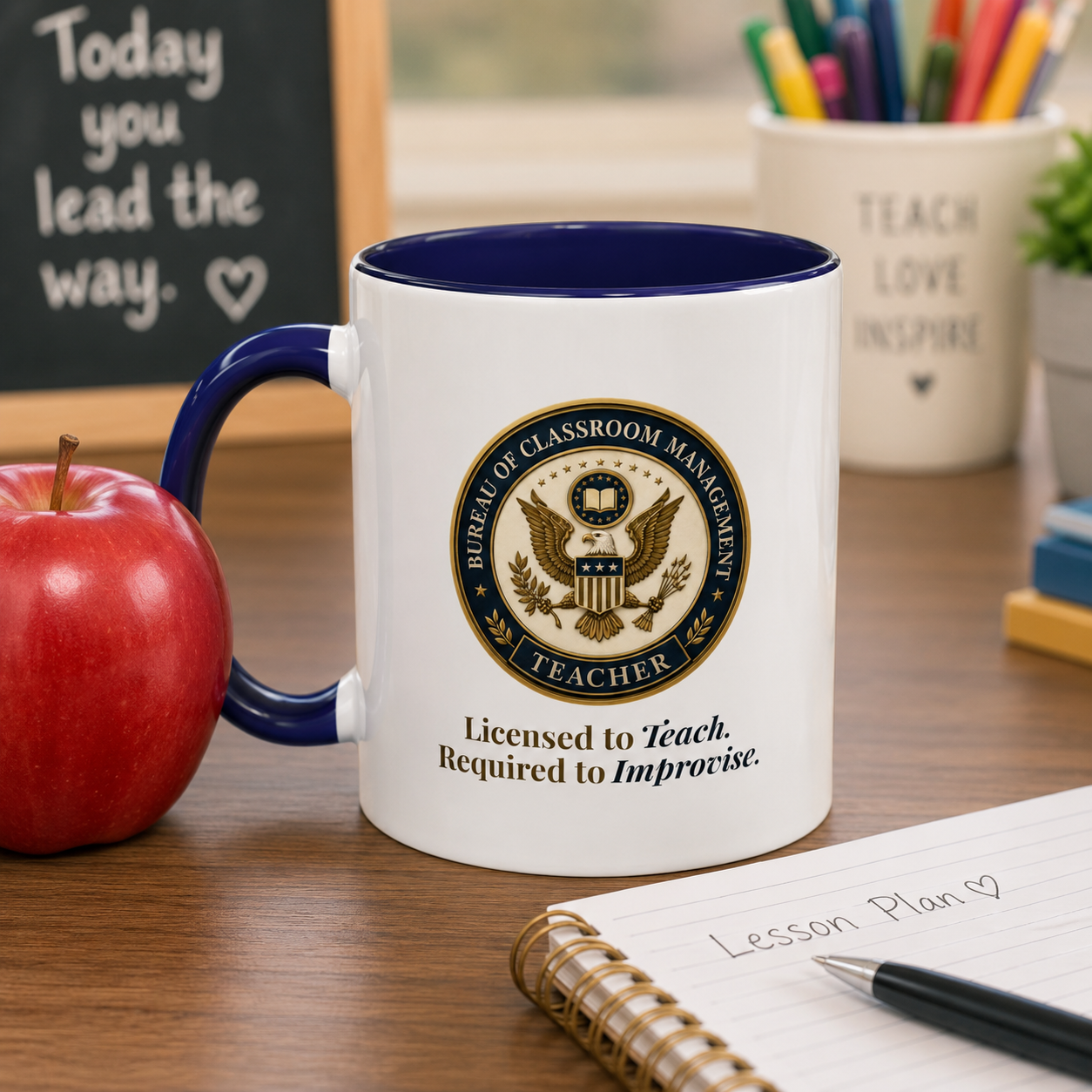 white and blue coffee mug sitting on a teacher's desk next to a red apple