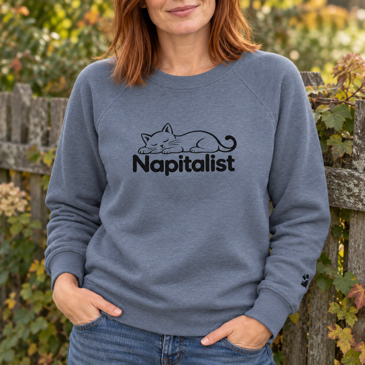 Woman wearing a slate blue Napitalist cat sweatshirt outdoors.